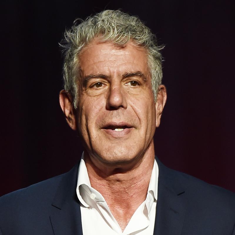 Anthony Bourdain speaks in a suit