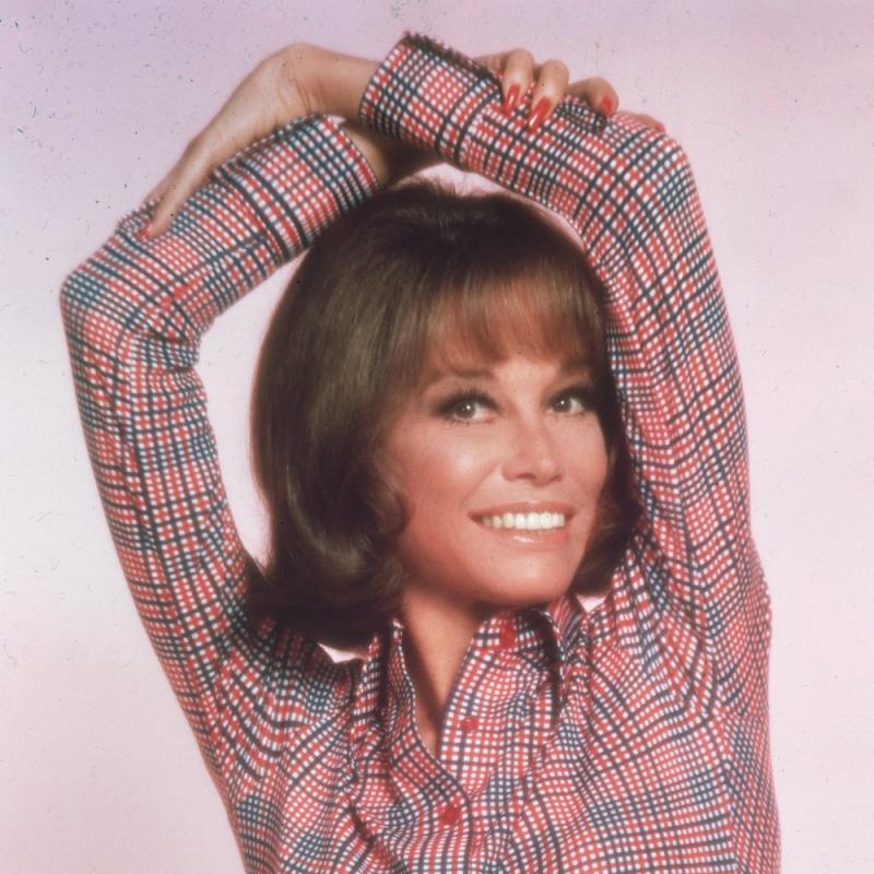 Actress Mary Tyler Moore poses with her arms folded over her head in this photo from 1975